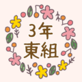 花リースの中に「3年東組」のロゴ