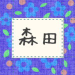 青い花柄の布地に名札が縫ってあるようなデザインの画像「森田」と手書き風で書いてある
