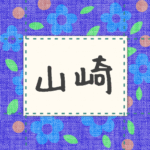 青い花柄の布地に名札が縫ってあるようなデザインの画像「山崎」と手書き風で書いてある